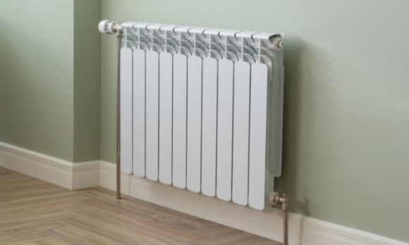 White radiator against green painted wall in home