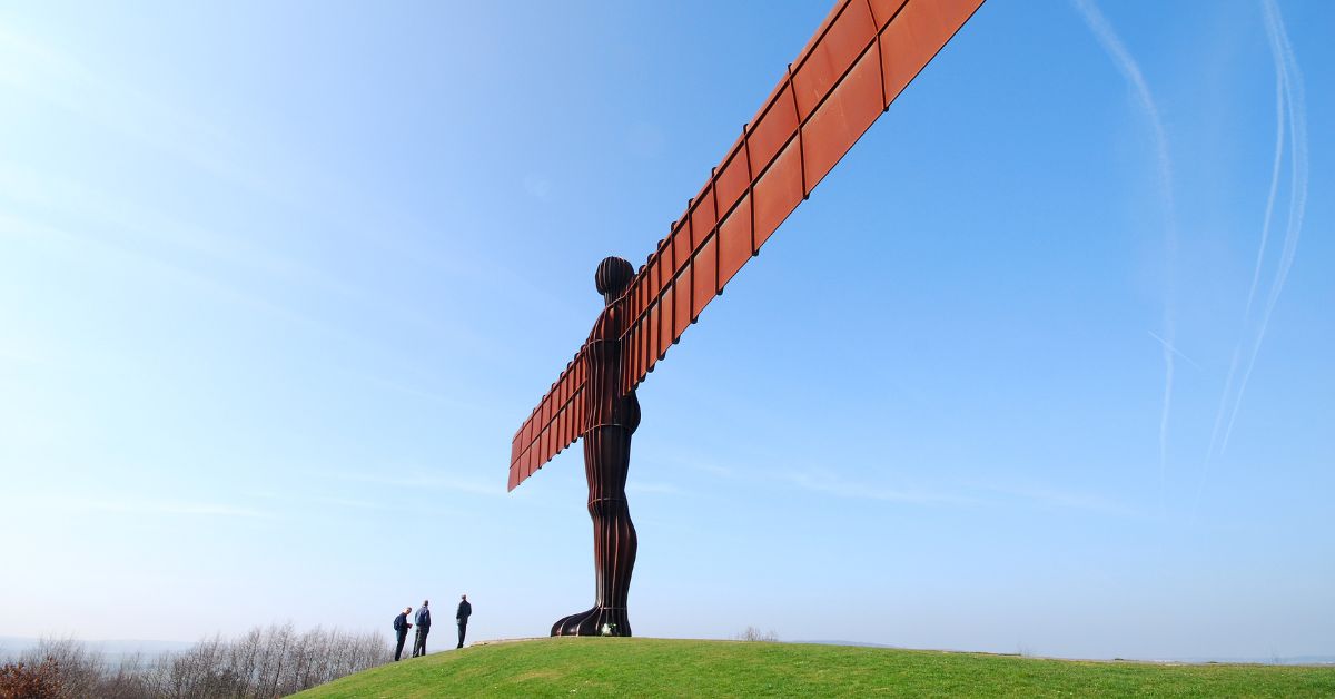 Tourists stand beneath Angel of the North statue near Gateshead