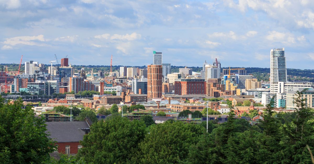 Skyline view of Leeds city centre with trees in foreground